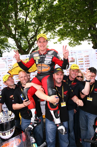 John McGuinness celebrates his 130mph+ Senior win with his Honda team